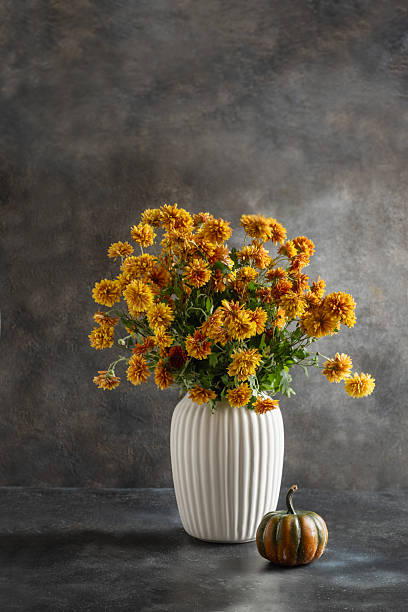 istock Autumn orange flowers in white vase 2235708740
