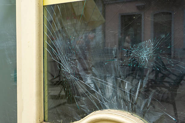 istock Damaged shop window with cracked glass, visible multiple spiderweb fractures and impact points, clear signs of vandalism. 2235709818