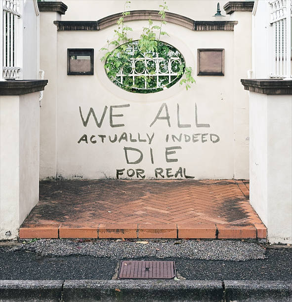 Large hand-painted text on a pale stucco wall in a recessed entryway reads \