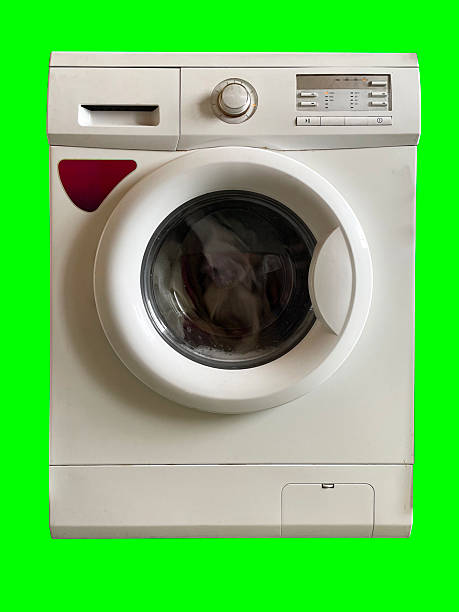Old rusty broken washing machine on a green background with a green window.