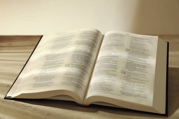istock Open Holy Bible in English language on beige table, closeup 2235713677