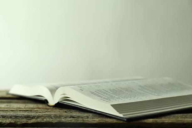 istock Open Holy Bible in English language on wooden table, closeup 2235713686