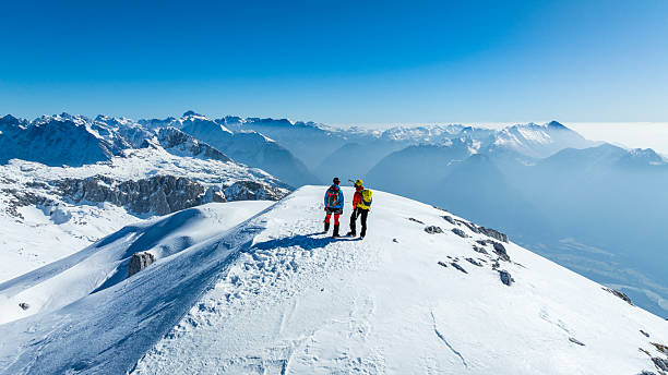 istock Mountaineers Standing on Snowy Mountain Summit 2235714184