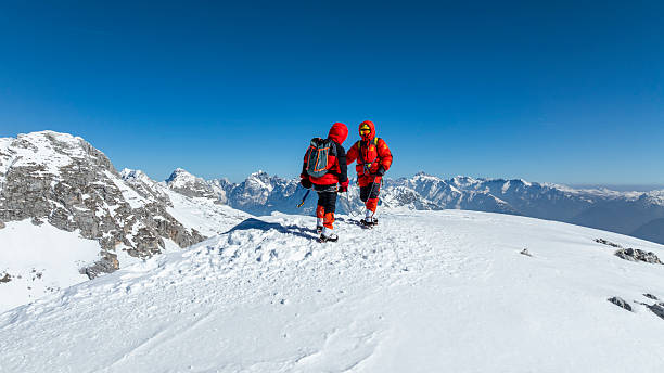 istock Mountaineers Rejoicing on Snowy Summit Under Clear Blue Sky 2235714204