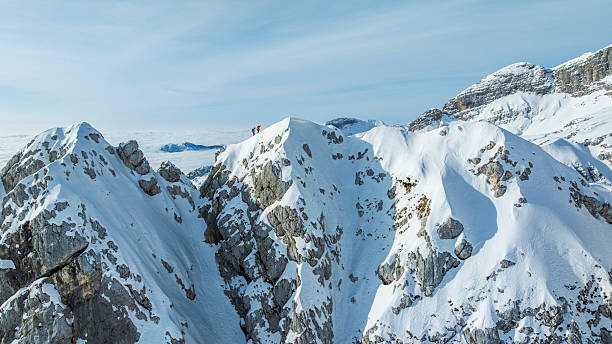 Adventurers Standing on Snow-covered Mountain Ridge