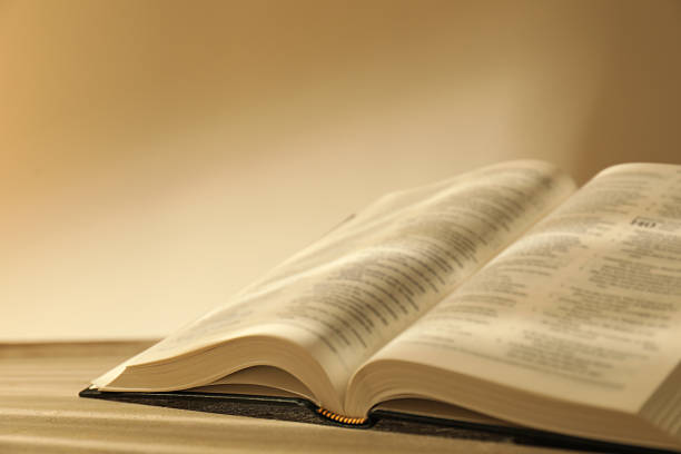 istock Open Holy Bible in English language on beige table, closeup 2235714260