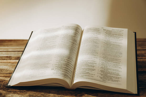 istock Open Holy Bible in English language on wooden table 2235714854