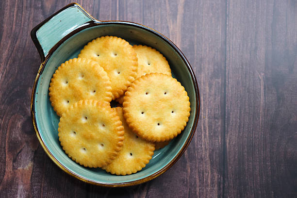 istock Light golden salted crackers with sprinkled salt on top. styled as a tea time snack. comfort food and savory bakery items. Crisp salted round biscuits. Copy space. great for food blogs. 2235716902