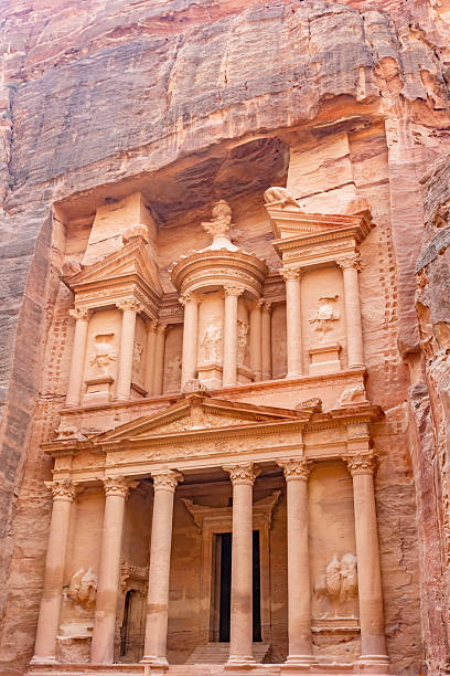 Local muslim man praying in front of an ancient ruin in Petra which is an ancient city, centre of an Arab kingdom in Hellenistic and Roman times, the ruins of which are in southwest Jordan which is an Arab nation on the east bank of the Jordan River, is defined by ancient monuments.