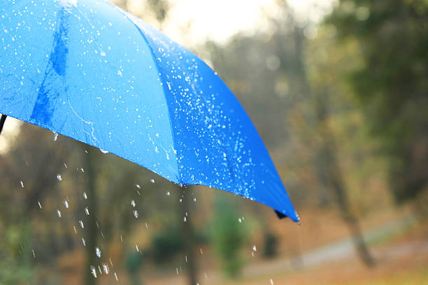 istock Open blue umbrella under pouring rain outdoors, closeup. Space for text 2235718650