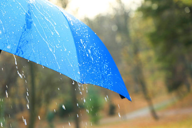 istock Open blue umbrella under pouring rain outdoors, closeup. Space for text 2235718652