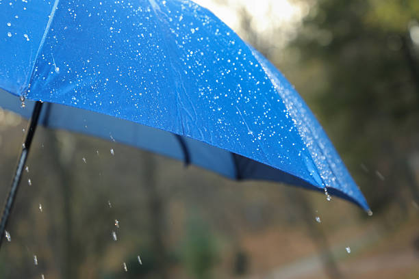 istock Open blue umbrella under pouring rain outdoors, closeup 2235718674