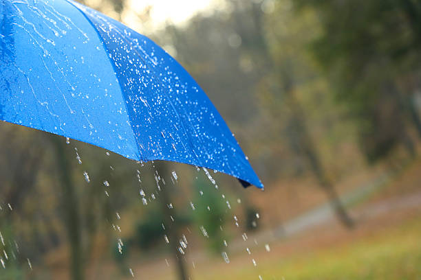istock Open blue umbrella under pouring rain outdoors, closeup. Space for text 2235718686