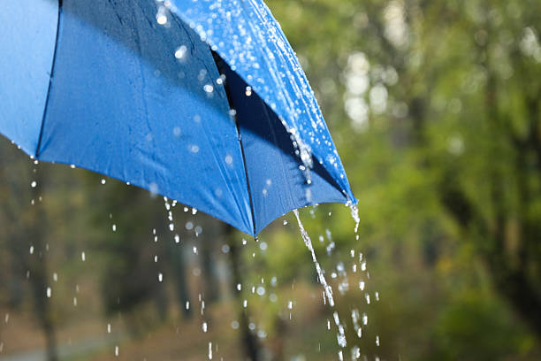 istock Open blue umbrella under pouring rain outdoors, closeup 2235718697