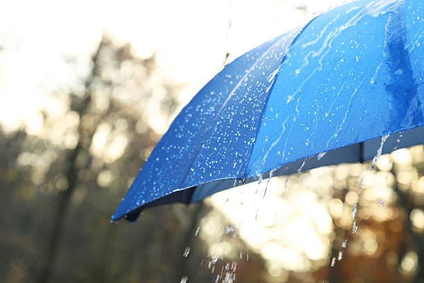 istock Open blue umbrella under pouring rain outdoors, closeup. Space for text 2235718707