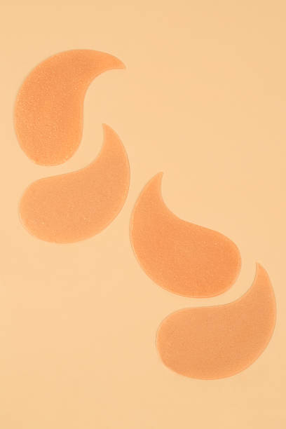 istock Cosmetic under-eye patches with shimmer on beige backdrop. 2235721929