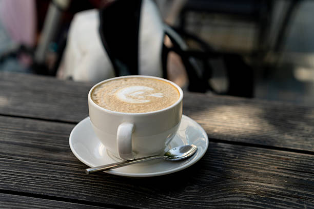 cup with cappuccino on wooden table. travel breakfast