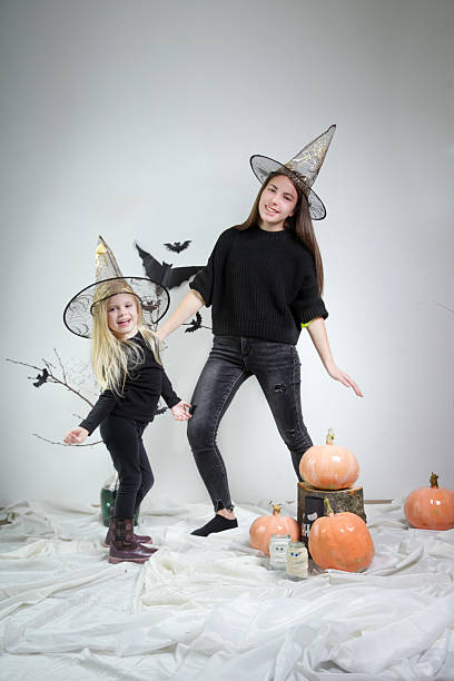 Little girl with witches hat hiding in the woods. Note for inspection; hat is not branded by any company, random hat.