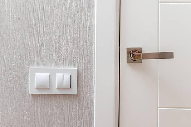istock A white door with a silver handle and a white switch on the wall 2235736810