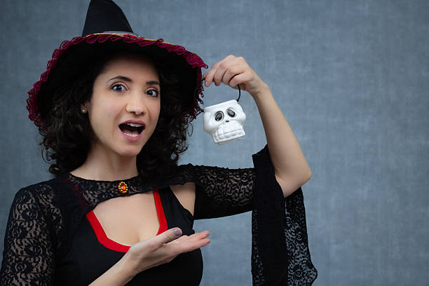 istock Funny witch amazed with a skull-shaped small basket. 2235736837
