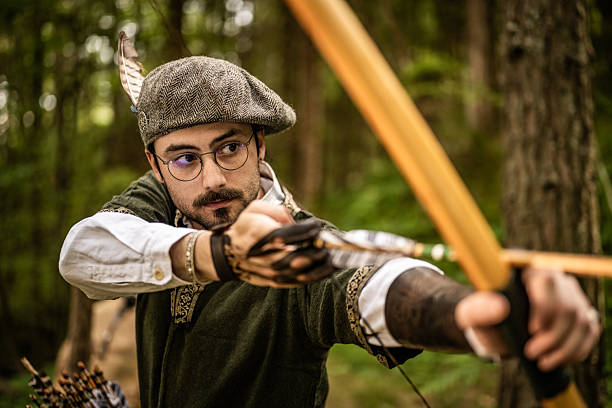 partial view of a person dressed in historical clothing with a quiver full of arrows, standing next to someone wearing modern jeans. The contrast between traditional and contemporary styles highlights the blend of past and present, making this image ideal for illustrating topics related to historical reenactments, traditional archery, outdoor festivals, and cultural heritage events