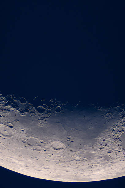 High-resolution shot reveals crater floor near lunar terminator. Moonâs terminator line, showcasing sharply defined craters, rugged mountain ranges and smooth lunar maria under low-angle sunlight.