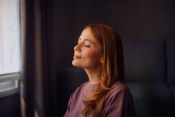 istock Smiling woman with eyes closed at home. 2235739980
