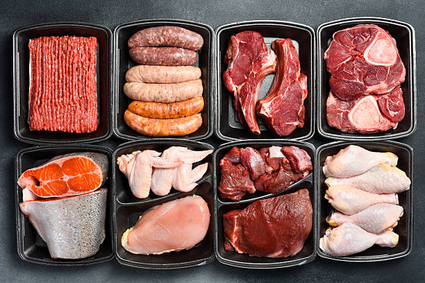 istock Black plastic packaging trays from supermarket with different types of fresh raw meat cuts, fresh beefbeef steaks, fish and variety meats in boxes from above 2235744669