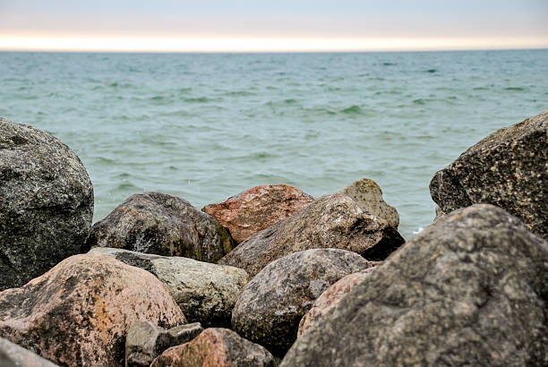 istock Rocky shoreline with ocean waves and cloudy sky at dusk 2235748783