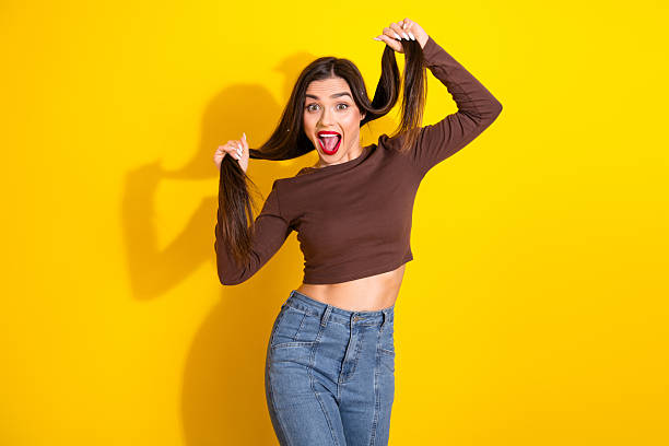 istock Joyful young woman with playful expression and vibrant background radiating positivity and natural beauty in casual stylish outfit 2235748842