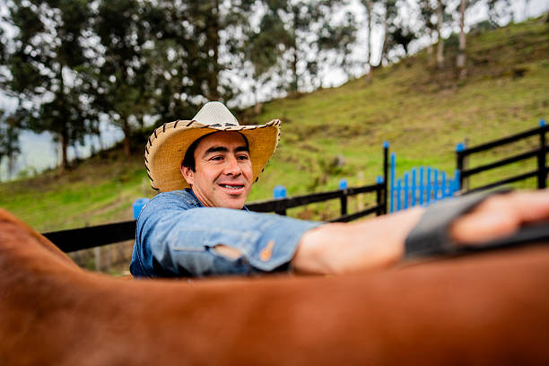 istock Farmer man brushing on horse on a stable 2235751964