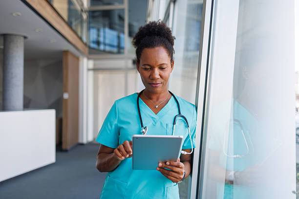 istock Confident mid adult nurse using digital tablet in hospital 2235752104