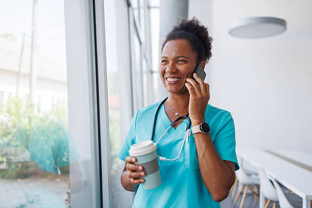 istock Smiling doctor having phone call during coffee break 2235752244