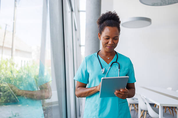 istock Smiling female doctor using digital tablet in hospital 2235752327