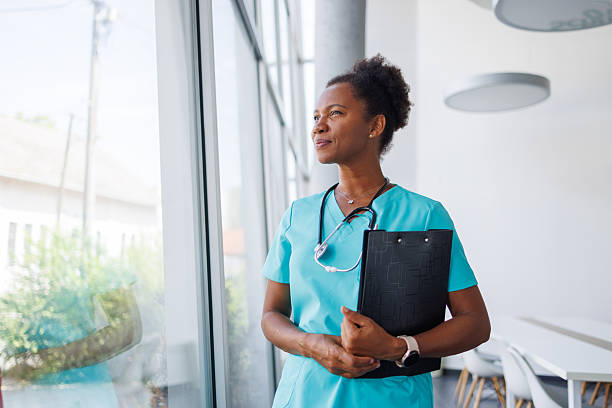 istock Confident mid adult doctor looking out window contemplating next move 2235752433
