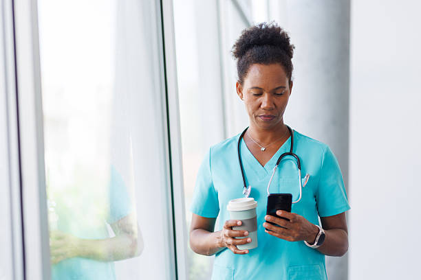 istock Focused nurse checking messages on phone during coffee break 2235752487