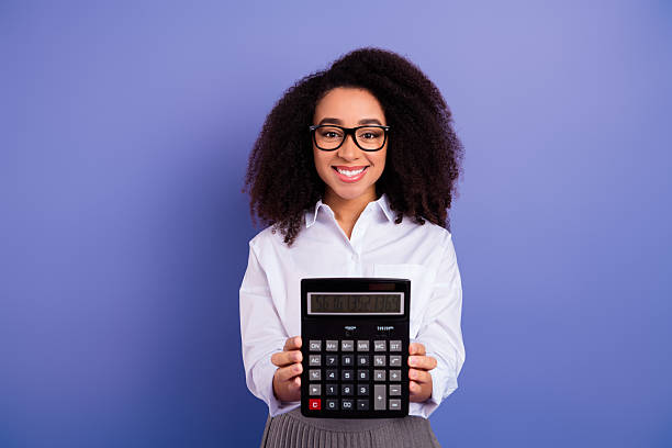 istock Lovely young woman proudly displaying a large electronic calculator against a solid violet background for professional themes 2235753373