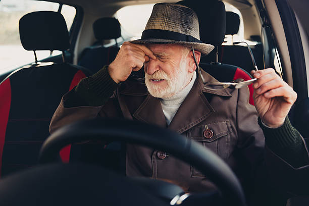 istock Elderly man experiencing discomfort while removing glasses inside a car during a sunny autumn day 2235753706