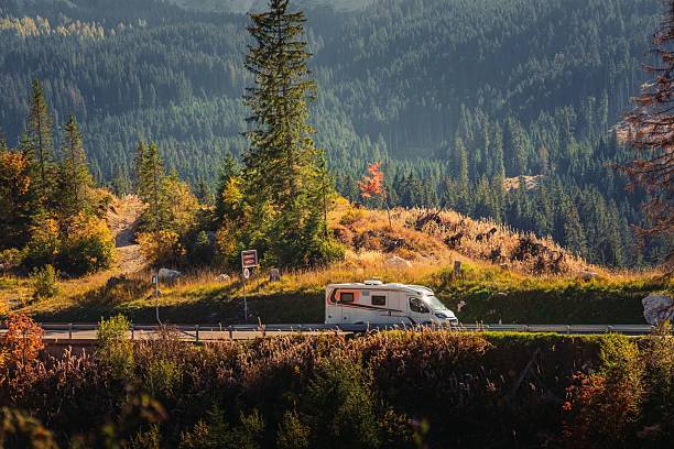 istock Camper van on a scenic mountain road with autumn foliage. 2235754102