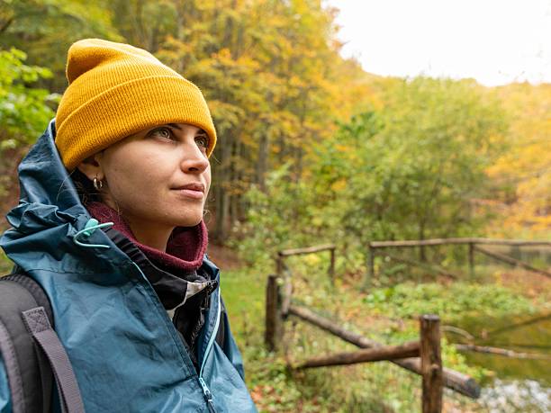 istock Woman exploring autumn forest in beanie. 2235754161