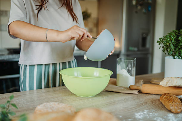 istock Young caucasian woman making bread dough in her kitchen 2235755477