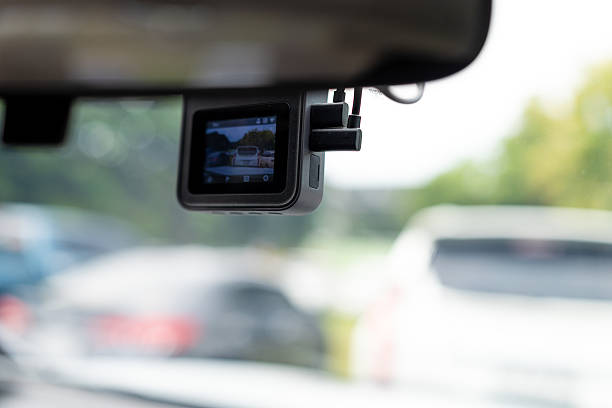 istock Car camera on the windshield,DVR camera on the windshield of the car close up,Person's hand holding the steering wheel and driving in the rain. 2235756493