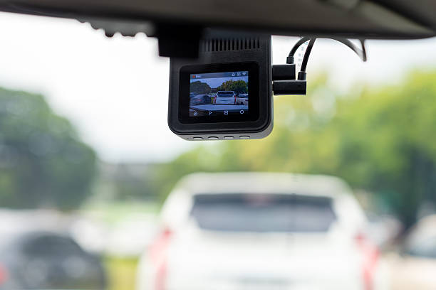 istock Car camera on the windshield,DVR camera on the windshield of the car close up,Person's hand holding the steering wheel and driving in the rain. 2235756495