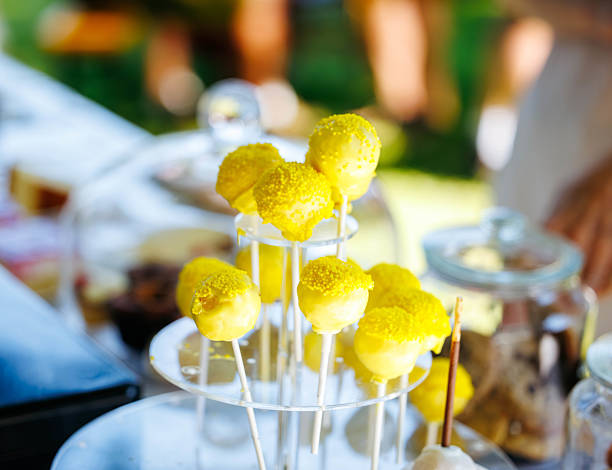 Delicious yellow cake pops on display stand