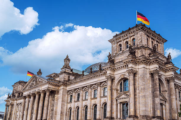 istock Historic Reichstag Building with German Flags in Daylight 2235760109