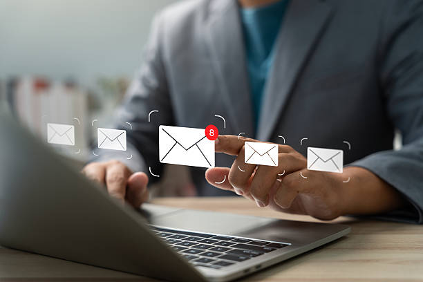 istock Businessman checking email notifications on laptop with digital mail icons. Concept of communication, inbox alert, email marketing, remote work, and modern business connectivity. 2235760126