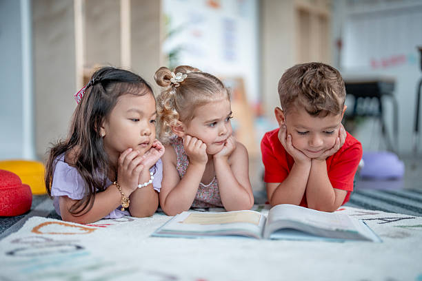 istock Diverse Group of Children Engaged in Reading a Book Together 2235760859