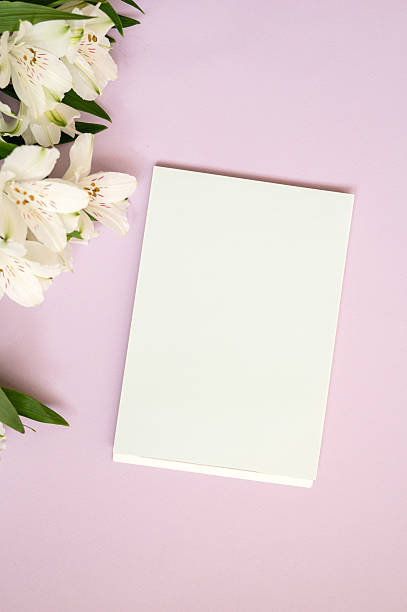istock Blank white notepad on pink background with white flowers 2235762795