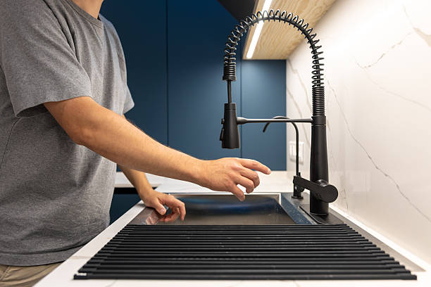 istock Person reaching for a matte black kitchen faucet. Before turning on water. 2235763206
