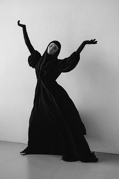 istock Graceful woman in black attire expressing emotion through elegant movement 2235763876